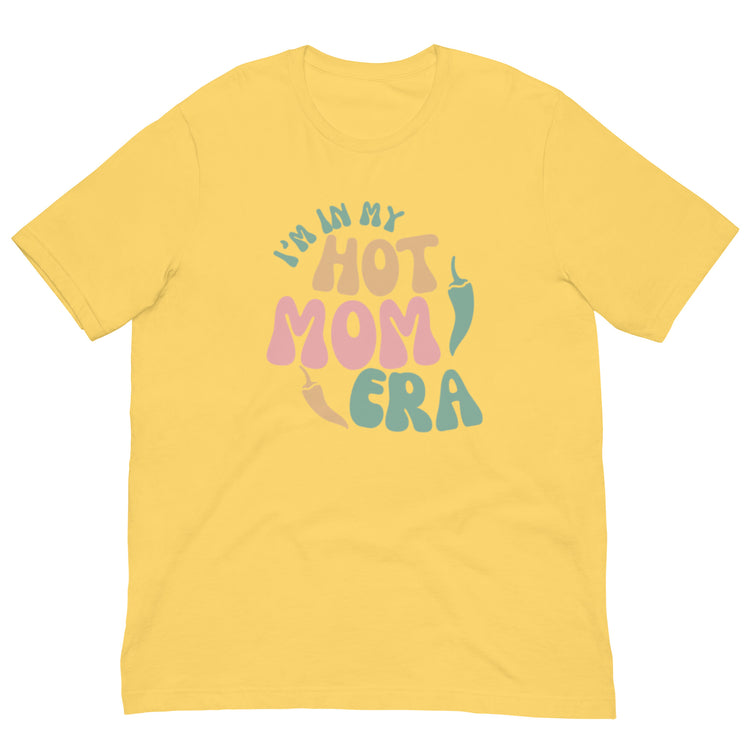 A bright yellow breathable Era Shirt with the phrase "i'm in my hot mom era" printed in playful multicolored letters on the front.