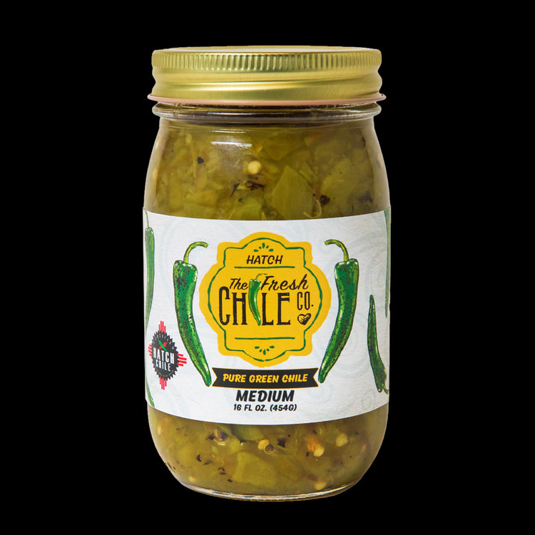 A jar of Pure Hatch Green Chile from the fresh chile co., labeled as medium heat, containing 16 oz. visible green chile pieces and seasoning within a sealed glass jar.